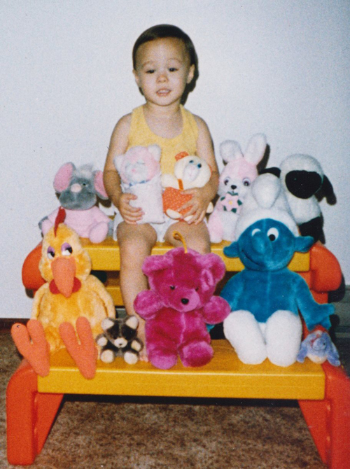 photo of child tiff surrounded by stuffed animals